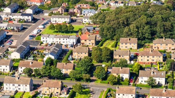 Aerial view of residential area with houses and cars