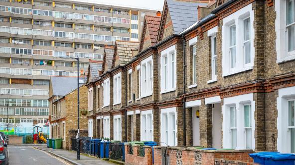 A row of houses in front of a block of flats.