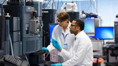 Healthcare scientists using a machine in a lab.