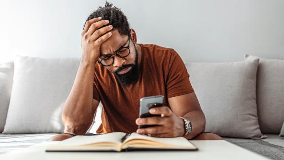 Man looking puzzled at mobile phone