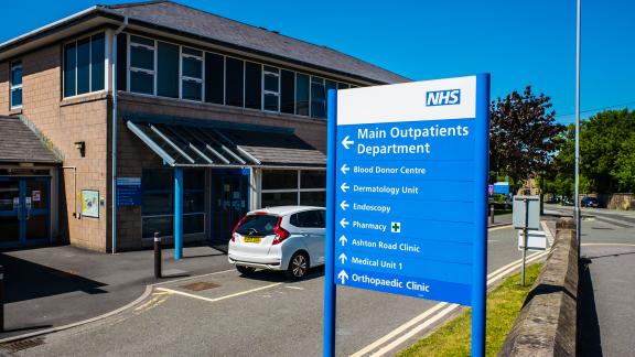 An NHS outpatients sign outside of a hospital.