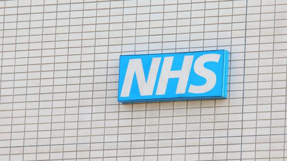 An NHS sign on the side of a building.