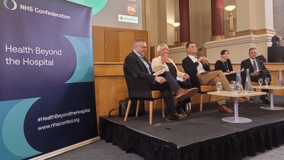 Seated panel on a raised stage. L-R: James Sanderson, Karen Jackson, Mathew Taylor, Miriam Deakin and Daniel Elkeles