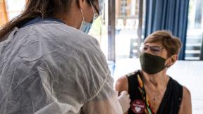A patient in a mask receives the COVID-19 vaccine.