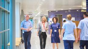 Healthcare workers walking down a hospital corridor.