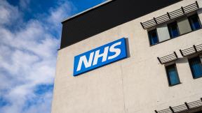 An NHS sign on the side of a building.