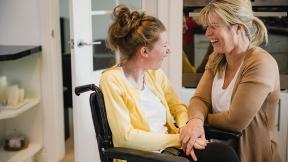 A patient and their carer, laughing.