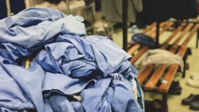 A pile of scrubs on a changing room bench.