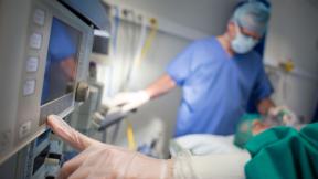 A surgeon touching a monitor.