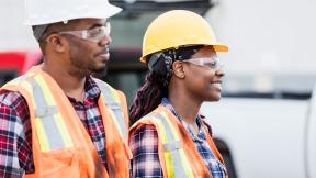 Two maintenance workers in hard hats and high visibility jackets.