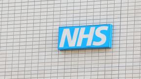 An NHS sign on the side of a building.