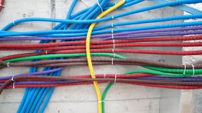 A group of electrical wires on a concrete wall.