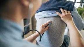 Doctor examining man's lungs with stethoscope 