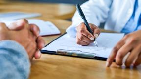 Doctor filling in form with patient