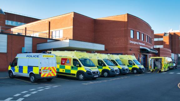 A row of ambulances outside a hospital.