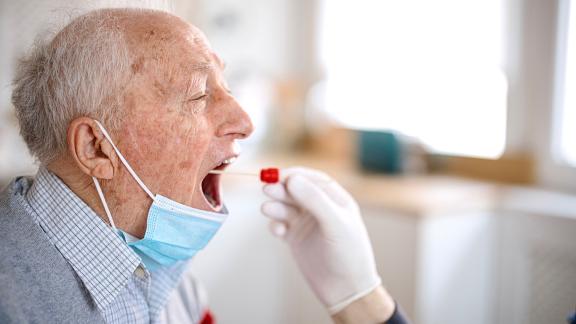 An elderly man being swabbed for a COVID-19 test.