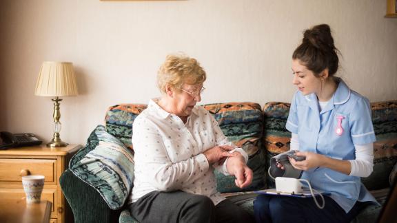 A community nurse checking a patient's temperature.