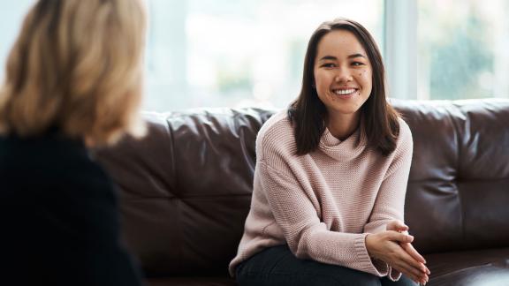 A woman in counselling, smiling.