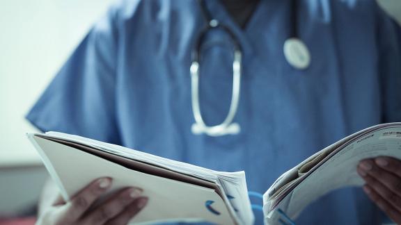 Close up of a doctor checking medical records.