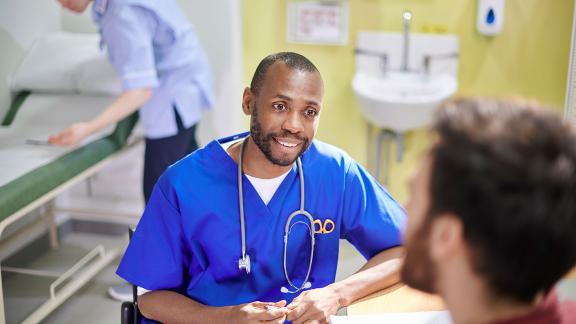 A doctor on a ward, consulting.