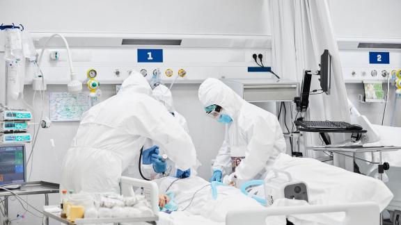 Doctors wearing PPE attending to a patient.