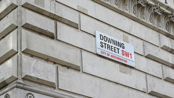 A street sign reading "Downing Street, SW1, City of Westminster".