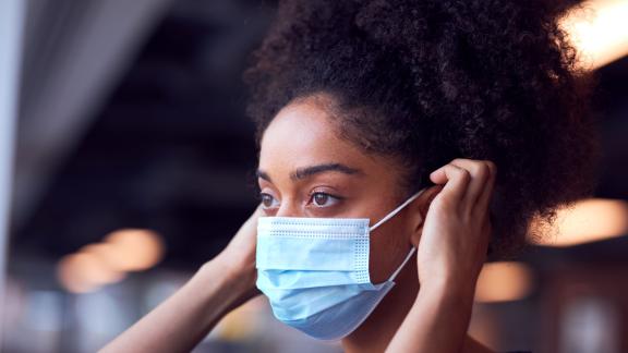 Female healthcare worker putting on mask