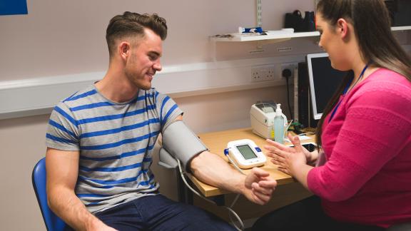 A general practitioner taking a patient's blood pressure.