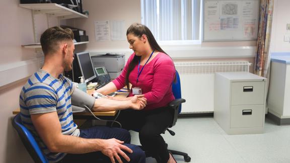 A general practitioner taking a patient's blood pressure.