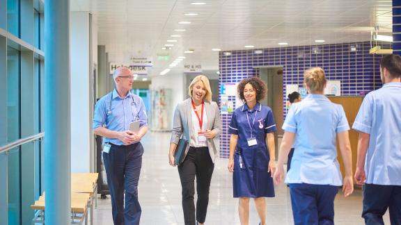 Healthcare workers walking down a hospital corridor.