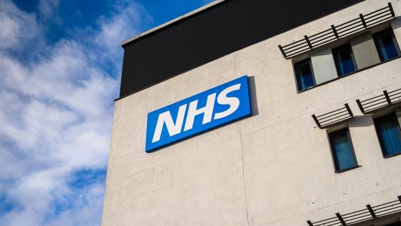 An NHS sign on the side of a building.