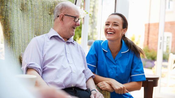 A patient and community nurse laughing.