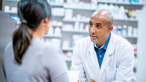 A pharmacist advising a customer.