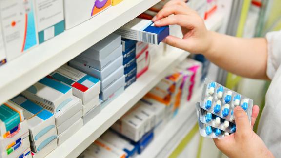 A pharmacist stacking a shelf.