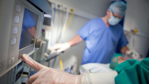 A surgeon touching a monitor.
