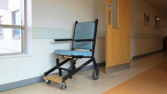A wheelchair in a hospital corridor.