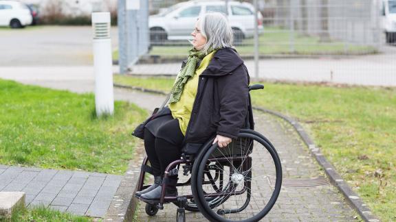 A wheelchair user stuck at the bottom of a ramp.