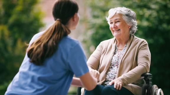 A wheelchair user talking to a nurse.