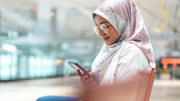 A woman on a bench, checking her phone.