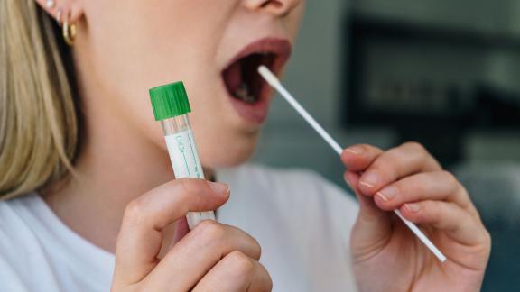 A woman using a COVID-19 self-swab test.