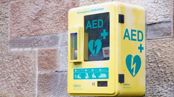 An emergency defibrillator mounted on an outside wall.