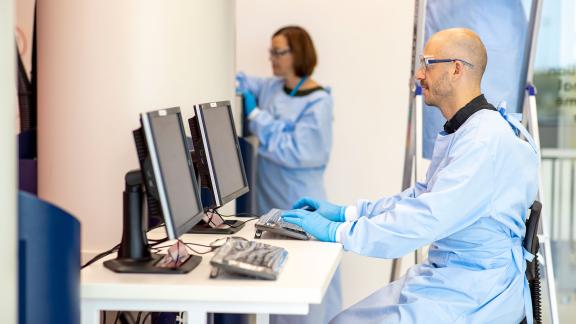 A healthcare scientist at a computer.