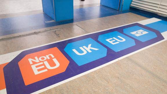 A floor sticker at an airport indicating different lanes for EU and non-EU passengers.