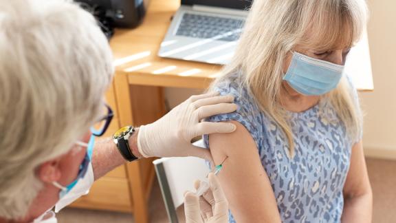 A masked patient receiving a vaccine.