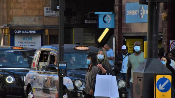 Masked people crossing a street.