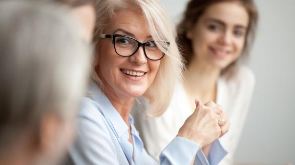 An office worker smiling in a meeting.