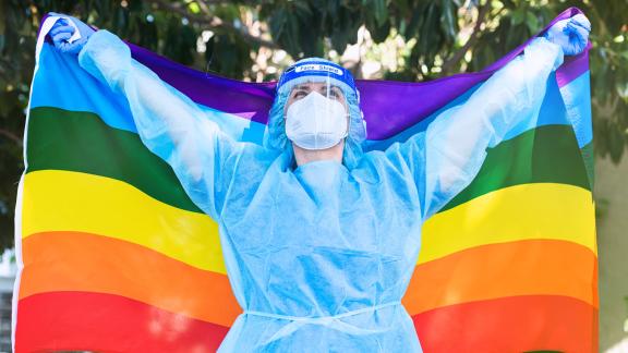 NHS staff in PPE holding LGBT flag