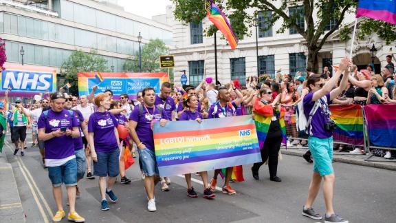 NHS staff marching in London Pride displaying LGBTQI Network banner
