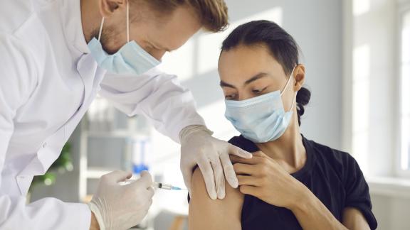 Doctor-or-nurse-giving-young-person-vaccination
