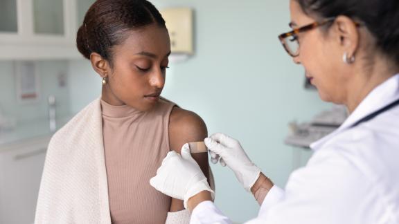 Doctor-or-nurse-giving-young-person-vaccination